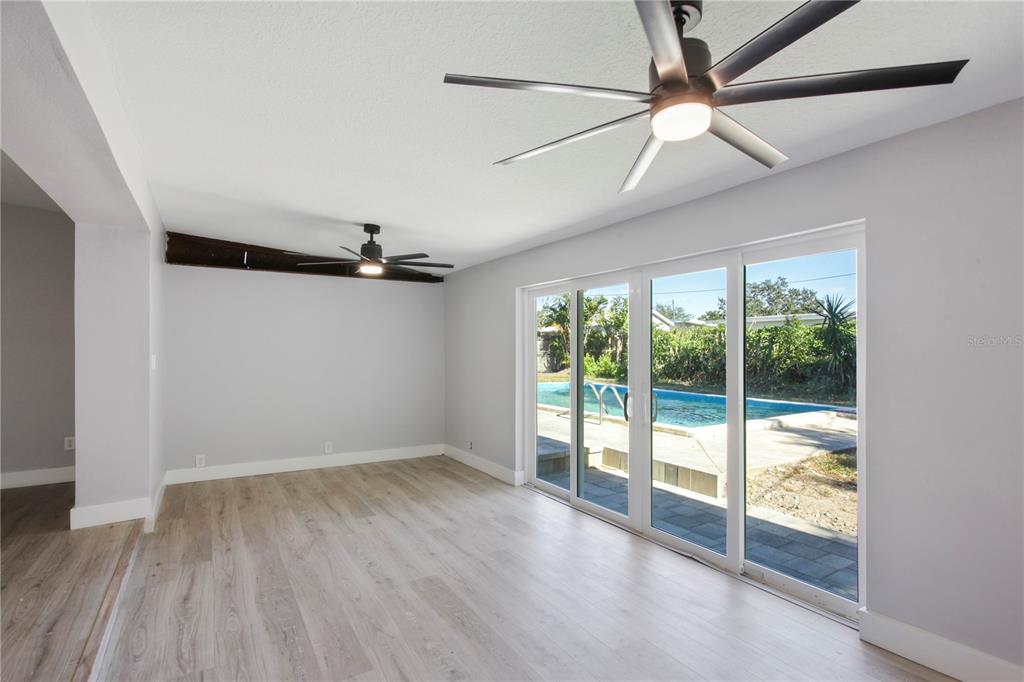 1407 Berwyn Road Orlando, FL 32806 - Photo 14 of 42 an empty room with wooden floor fan and windows