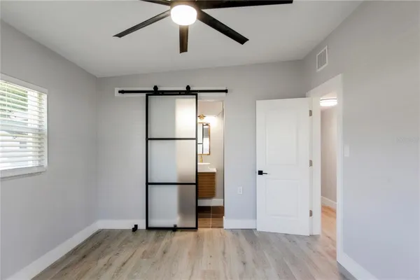 a view of empty room with wooden floor and window