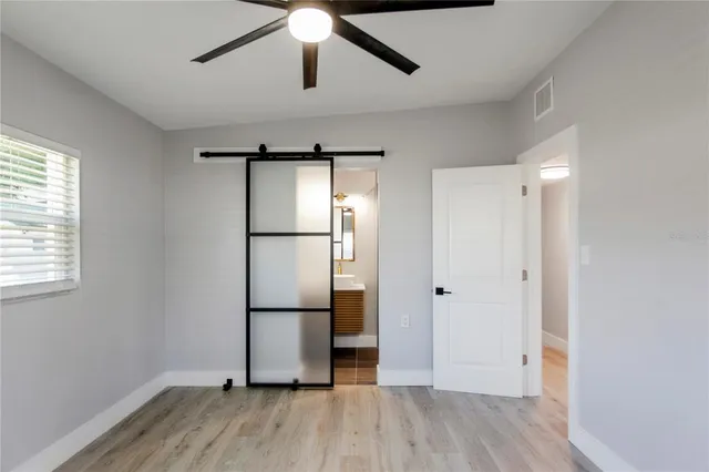 a view of empty room with wooden floor and window