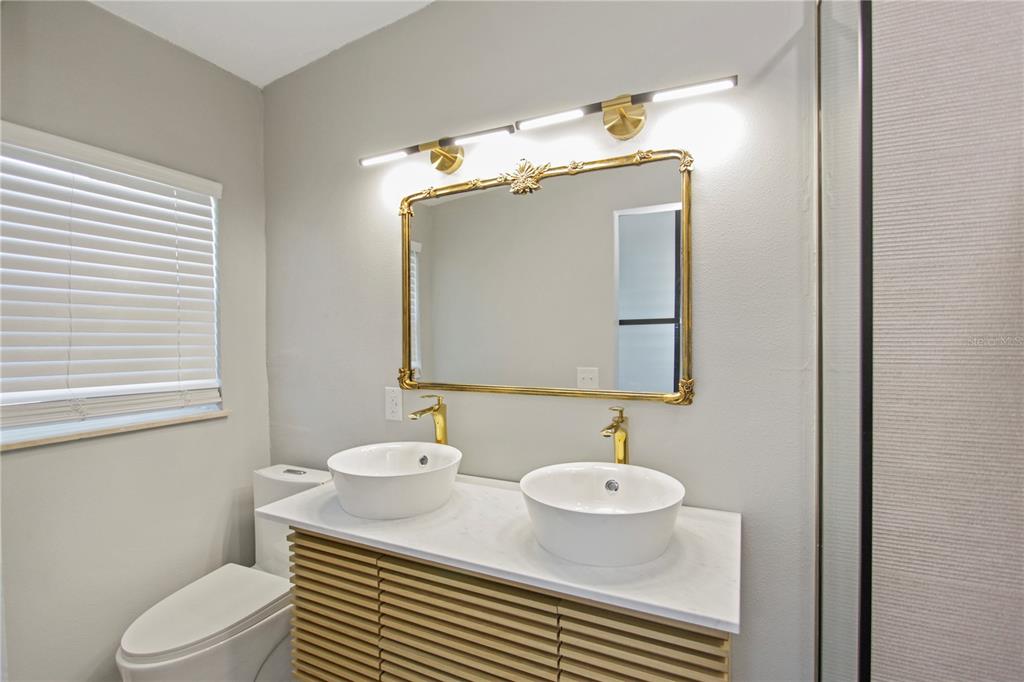 1407 Berwyn Road Orlando, FL 32806 - Photo 23 of 42 a bathroom with a granite countertop sink mirror vanity and toilet