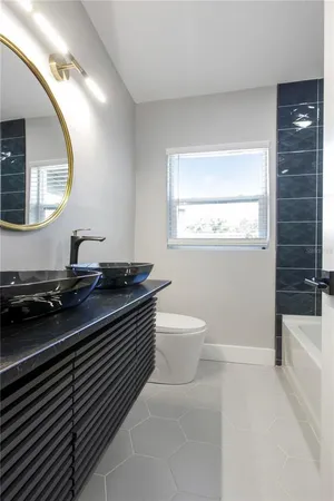 a spacious bathroom with a granite countertop toilet a sink and a mirror