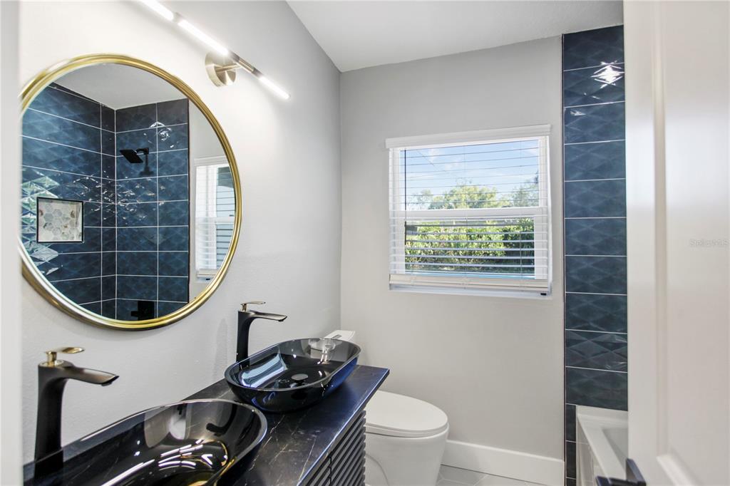 1407 Berwyn Road Orlando, FL 32806 - Photo 30 of 42 a bathroom with a toilet a sink and a mirror