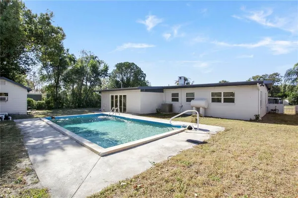 a view of the house with backyard and trees