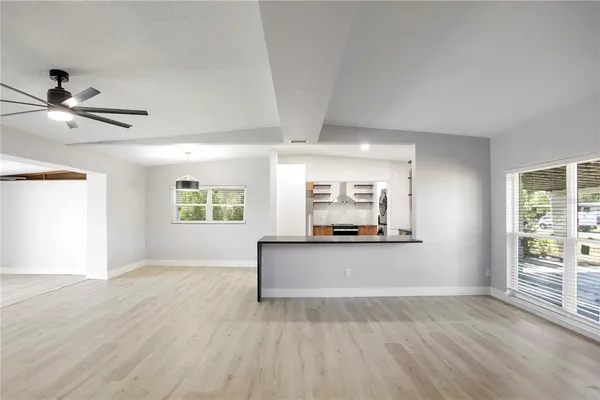 a view of a livingroom with furniture a ceiling fan and window