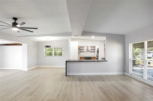 a view of a livingroom with furniture a ceiling fan and window