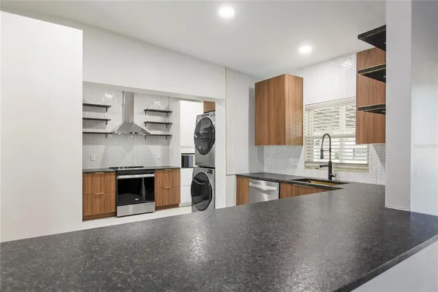 a kitchen with stainless steel appliances granite countertop a stove and a sink