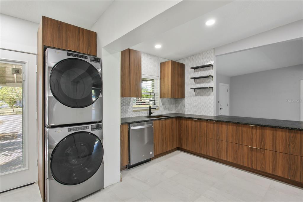 1407 Berwyn Road Orlando, FL 32806 - Photo 8 of 42 a kitchen with stainless steel appliances granite countertop a sink and a washer dryer