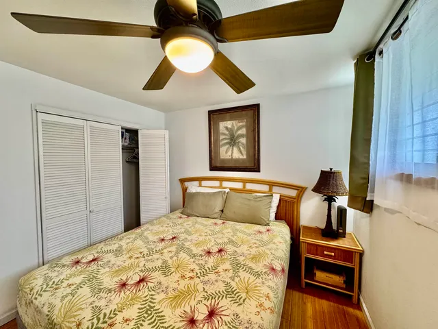 a bedroom with a large bed and a flat tv screen on dresser