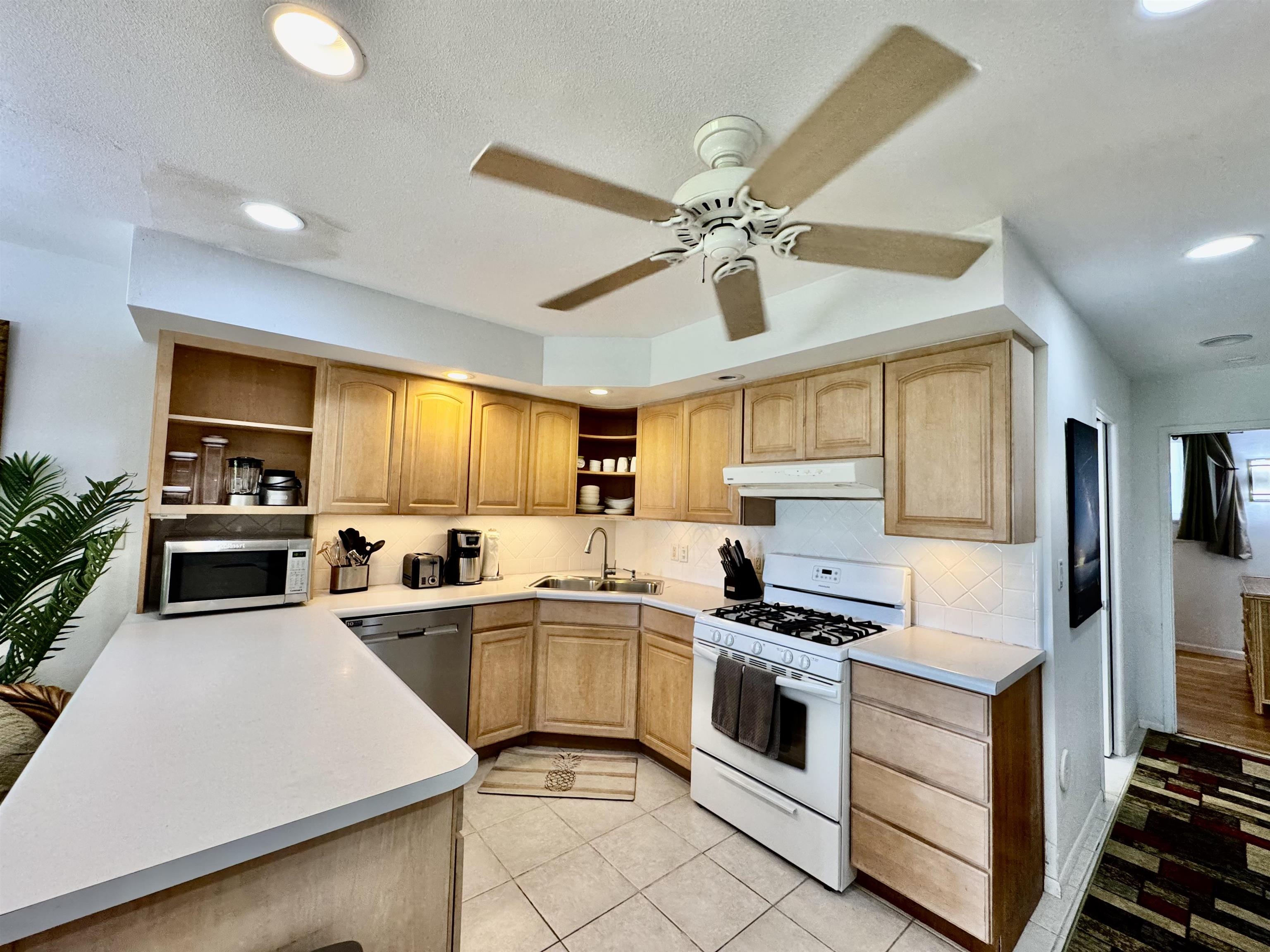 7142 Kamehameha V Highway, Unit A110 Kaunakakai, HI 96748 - Photo 6 of 20 a kitchen with a stove a sink and a refrigerator