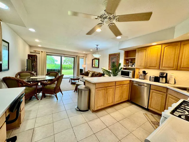 a living room with furniture a flat screen tv and kitchen view