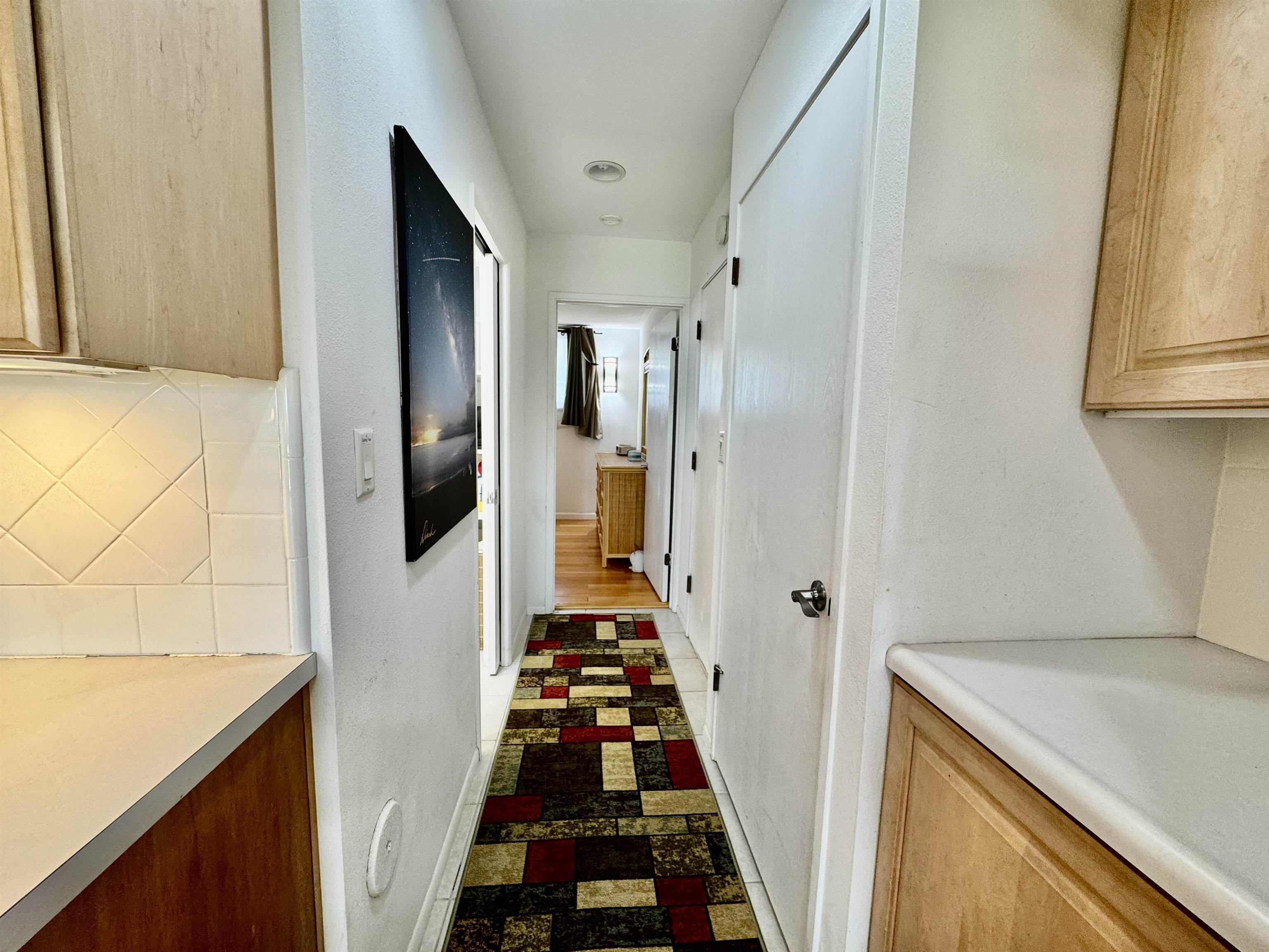 7142 Kamehameha V Highway, Unit A110 Kaunakakai, HI 96748 - Photo 10 of 20 a view of a hallway with wooden floor and cabinets