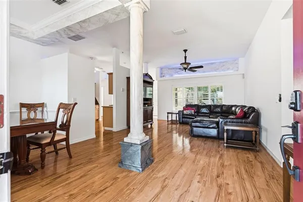 a living room with furniture ceiling fan and a wooden floor