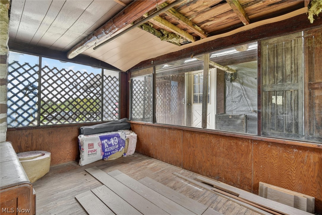 1526 Stevenson Road Ashtabula, OH 44004 - Photo 30 of 50 Enclosed porch featuring wood-finish wall panels, wood-finish flooring, and a curved slatted ceiling with exposed beams