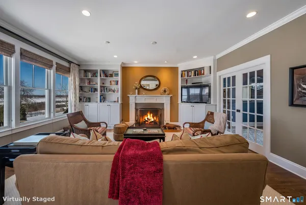 a living room with furniture a fireplace and a large window