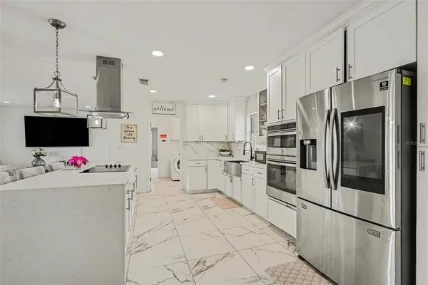 a kitchen with stainless steel appliances a refrigerator sink and microwave
