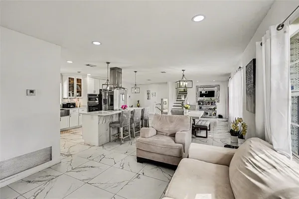 a living room with furniture and a dining table with kitchen view
