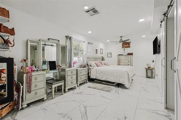 a bedroom with furniture and a flat screen tv