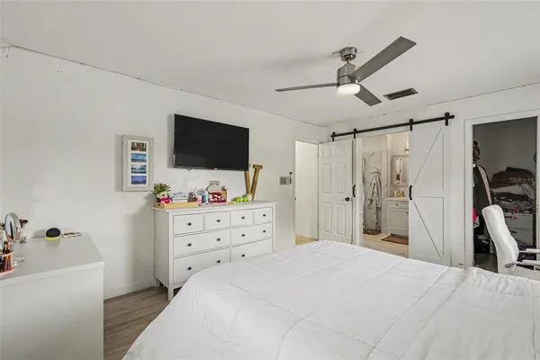 a bedroom with a bed and a flat tv screen on the dresser