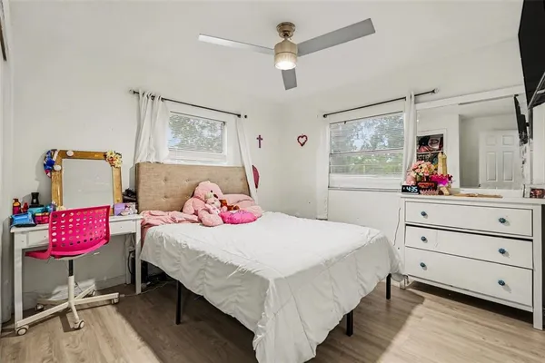 a bedroom with a bed and wooden floor
