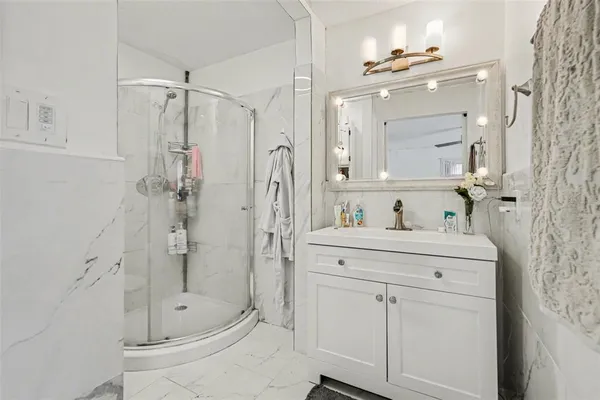 a bathroom with a shower a sink and mirror
