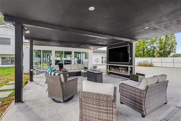 a living room with couches a flat screen tv and a large window