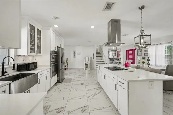 a large kitchen with stainless steel appliances kitchen island granite countertop a sink and cabinets