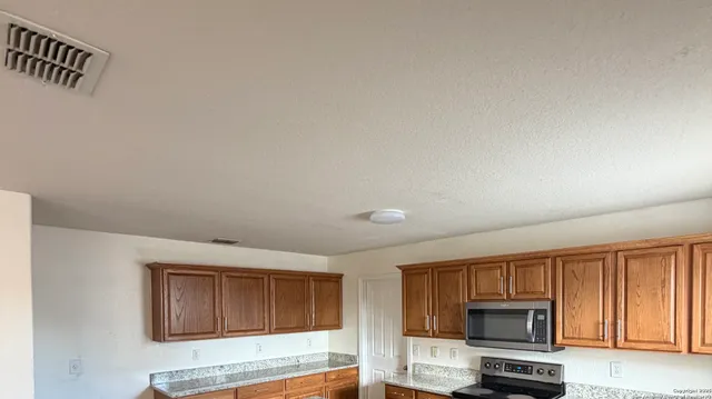 a view of kitchen with microwave and cabinets