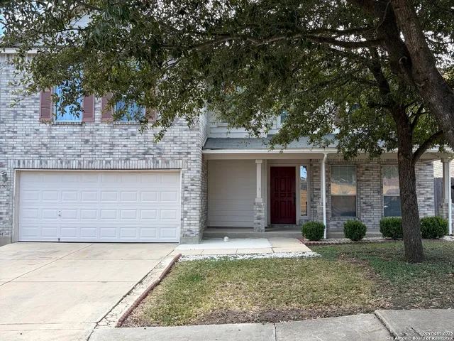 front view of a house with a yard and garage