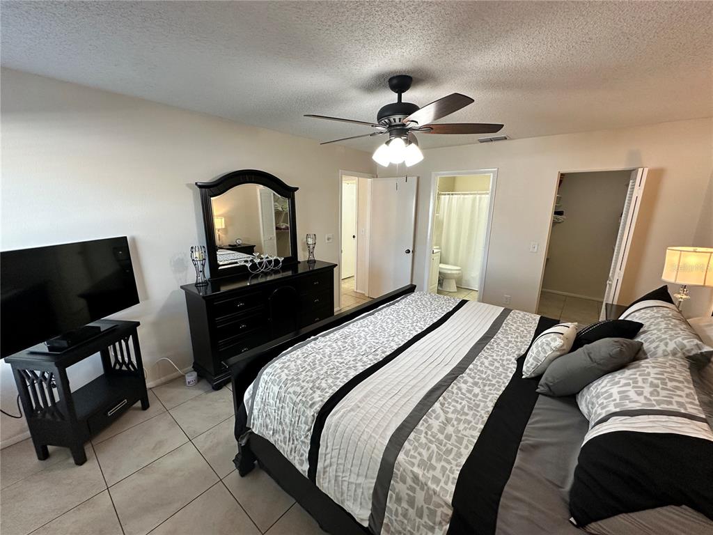 3846 59th Avenue West, Unit 3846 Bradenton, FL 34210 - Photo 11 of 25 a bedroom with a bed and a flat screen tv