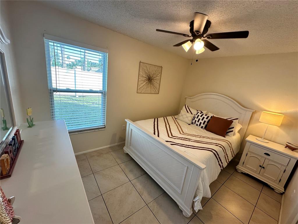 3846 59th Avenue West, Unit 3846 Bradenton, FL 34210 - Photo 14 of 25 a bedroom with a bed and a ceiling fan
