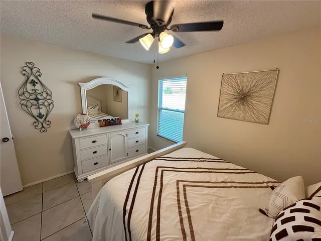 a bedroom with a bed and a ceiling fan