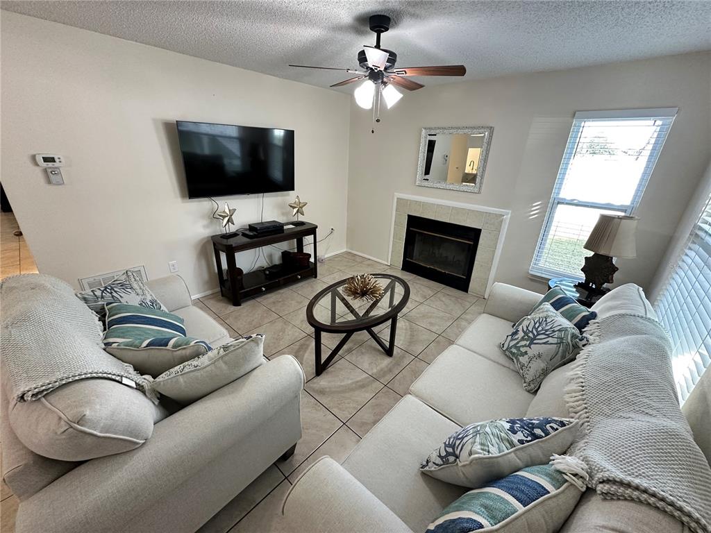 3846 59th Avenue West, Unit 3846 Bradenton, FL 34210 - Photo 2 of 25 a living room with furniture a fireplace and a flat screen tv