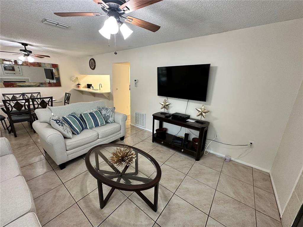 3846 59th Avenue West, Unit 3846 Bradenton, FL 34210 - Photo 3 of 25 a living room with furniture and a flat screen tv