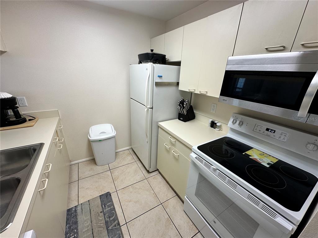 3846 59th Avenue West, Unit 3846 Bradenton, FL 34210 - Photo 7 of 25 a kitchen with a sink a stove and cabinets