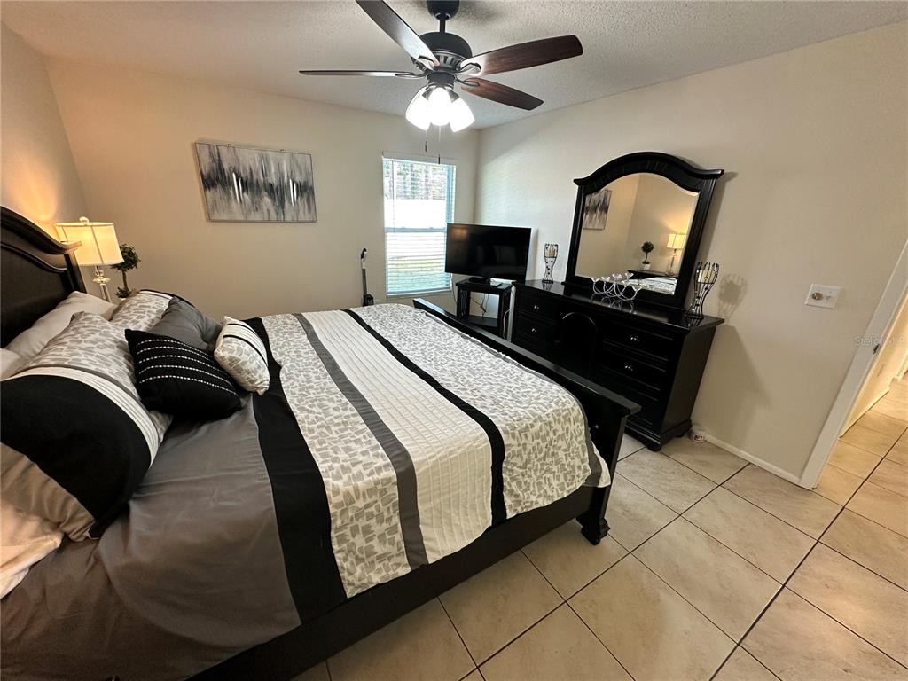 3846 59th Avenue West, Unit 3846 Bradenton, FL 34210 - Photo 9 of 25 a bedroom with a bed and a chandelier