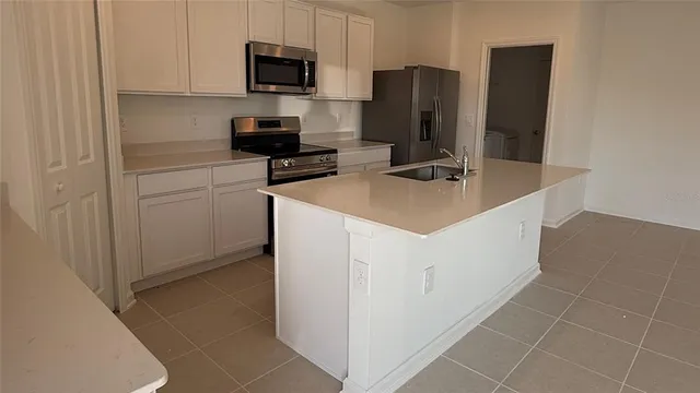 a kitchen with appliances a sink and cabinets