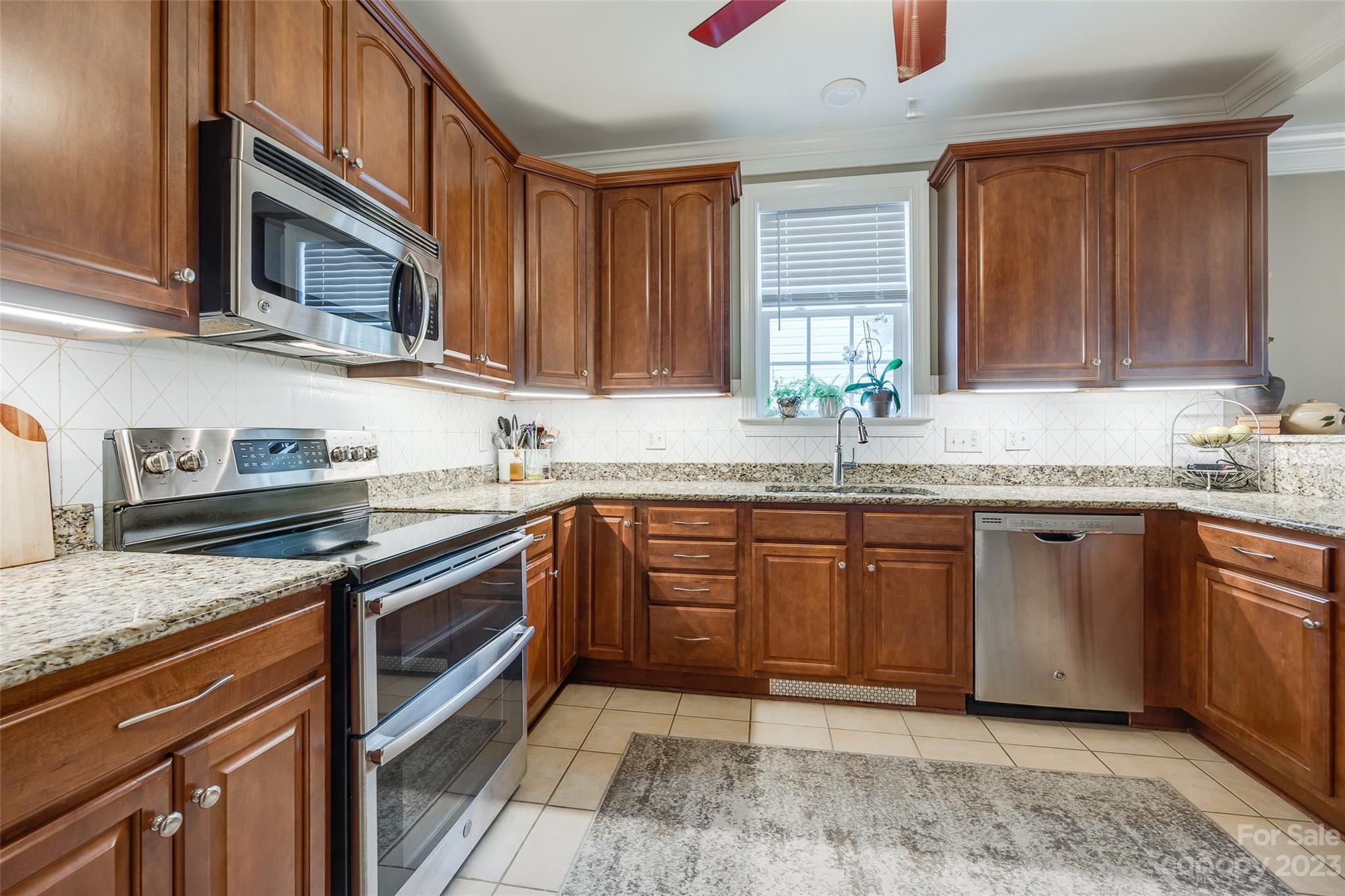 4142 Sunset Ridge Drive, Unit 117 Rock Hill, SC 29732 - Photo 7 of 48 a kitchen with stainless steel appliances granite countertop a sink stove and microwave