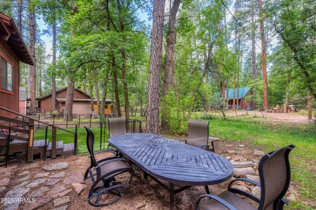 a view of a table and chairs in backyard of the house