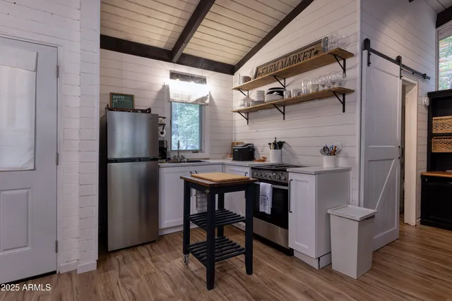 a kitchen with stainless steel appliances a refrigerator a table and chairs