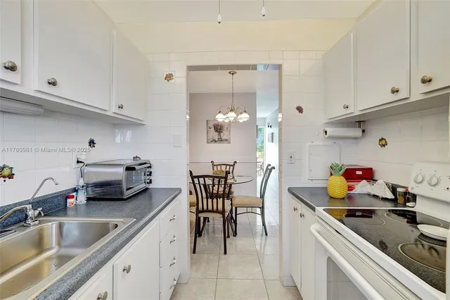 a kitchen with appliances a sink and cabinets