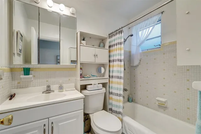 a bathroom with a sink toilet vanity and tub