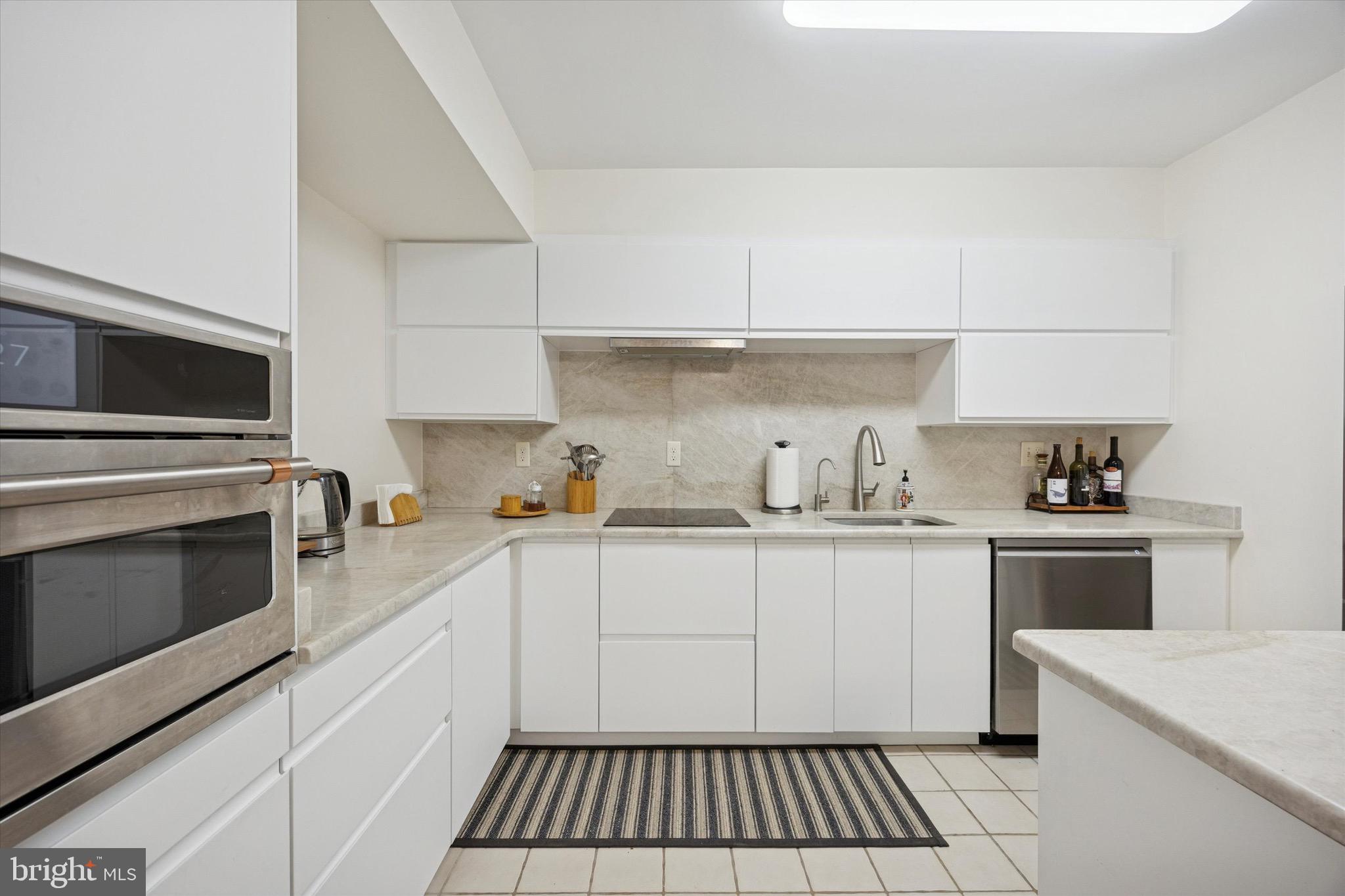 1704 North Park Drive, Unit A409 Wilmington, DE 19806 - Photo 11 of 25 a kitchen with granite countertop a sink a stove and cabinets