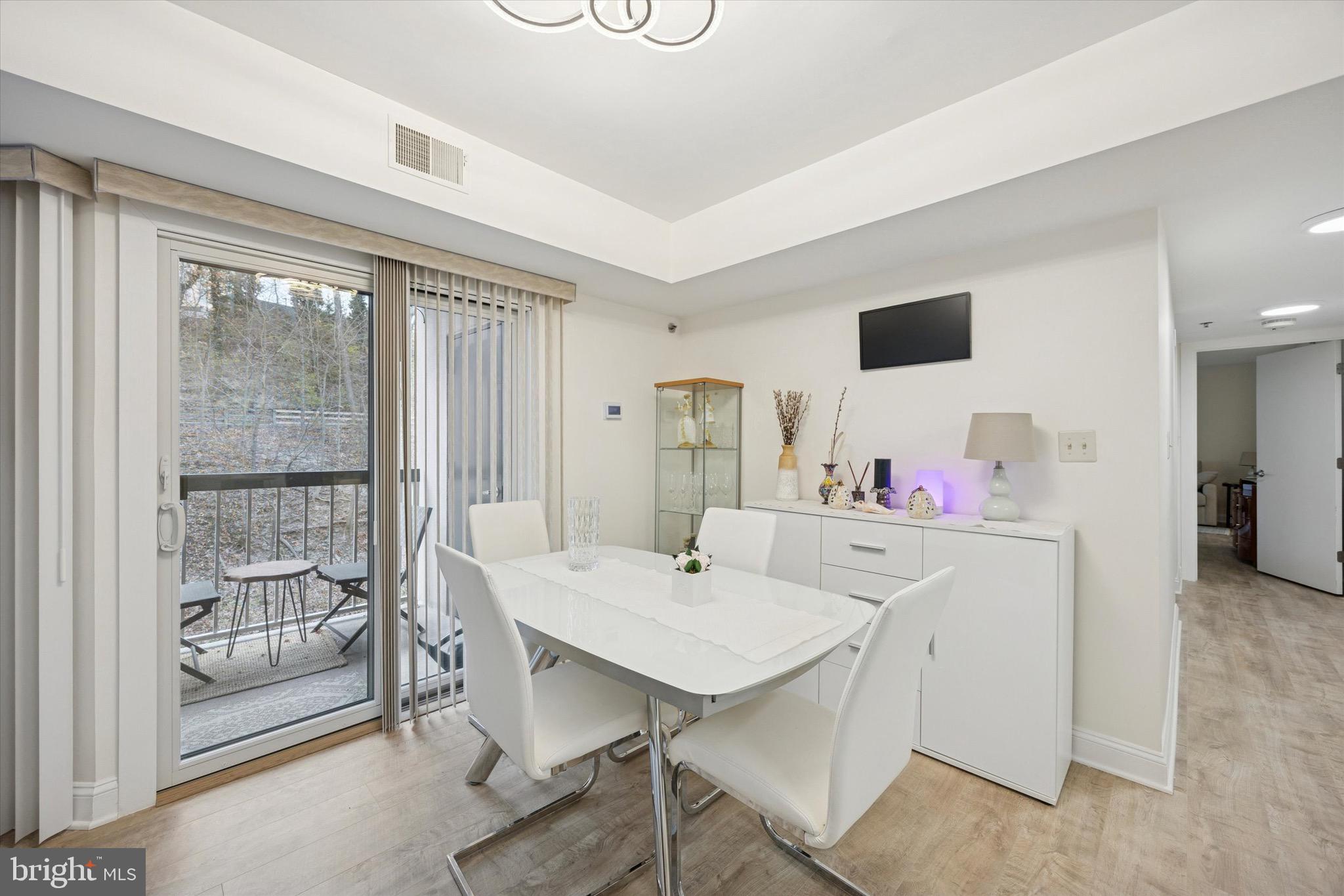 1704 North Park Drive, Unit A409 Wilmington, DE 19806 - Photo 15 of 25 a view of a dining room with furniture and a floor to ceiling window