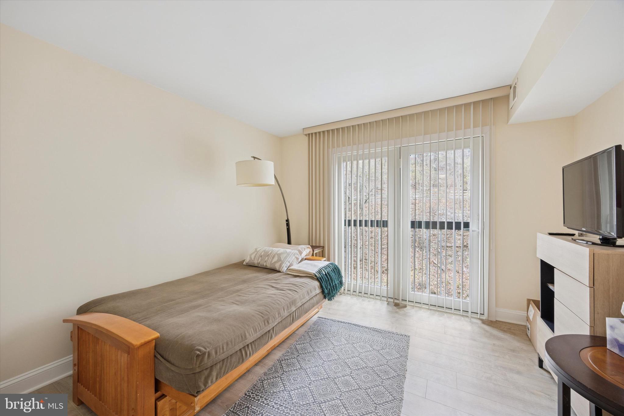 1704 North Park Drive, Unit A409 Wilmington, DE 19806 - Photo 8 of 25 a bedroom with a bed and a flat screen tv