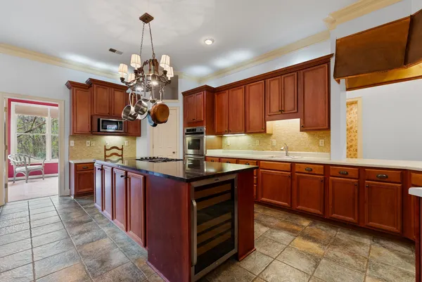 a kitchen with kitchen island granite countertop a sink dishwasher stove and cabinets