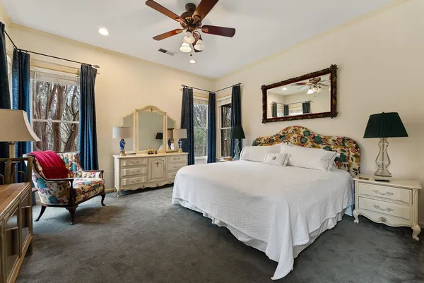 a bedroom with a bed and dresser with chair