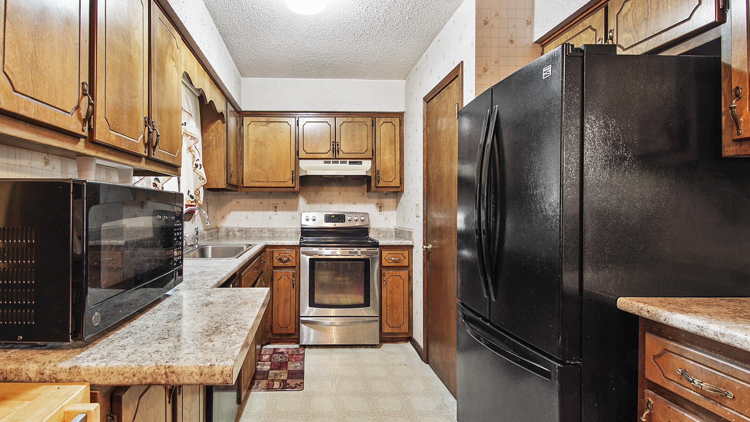6022 Old Bethel Road Crestview, FL 32536 - Photo 7 of 19 a kitchen with stainless steel appliances granite countertop a refrigerator a stove and a sink with wooden floor