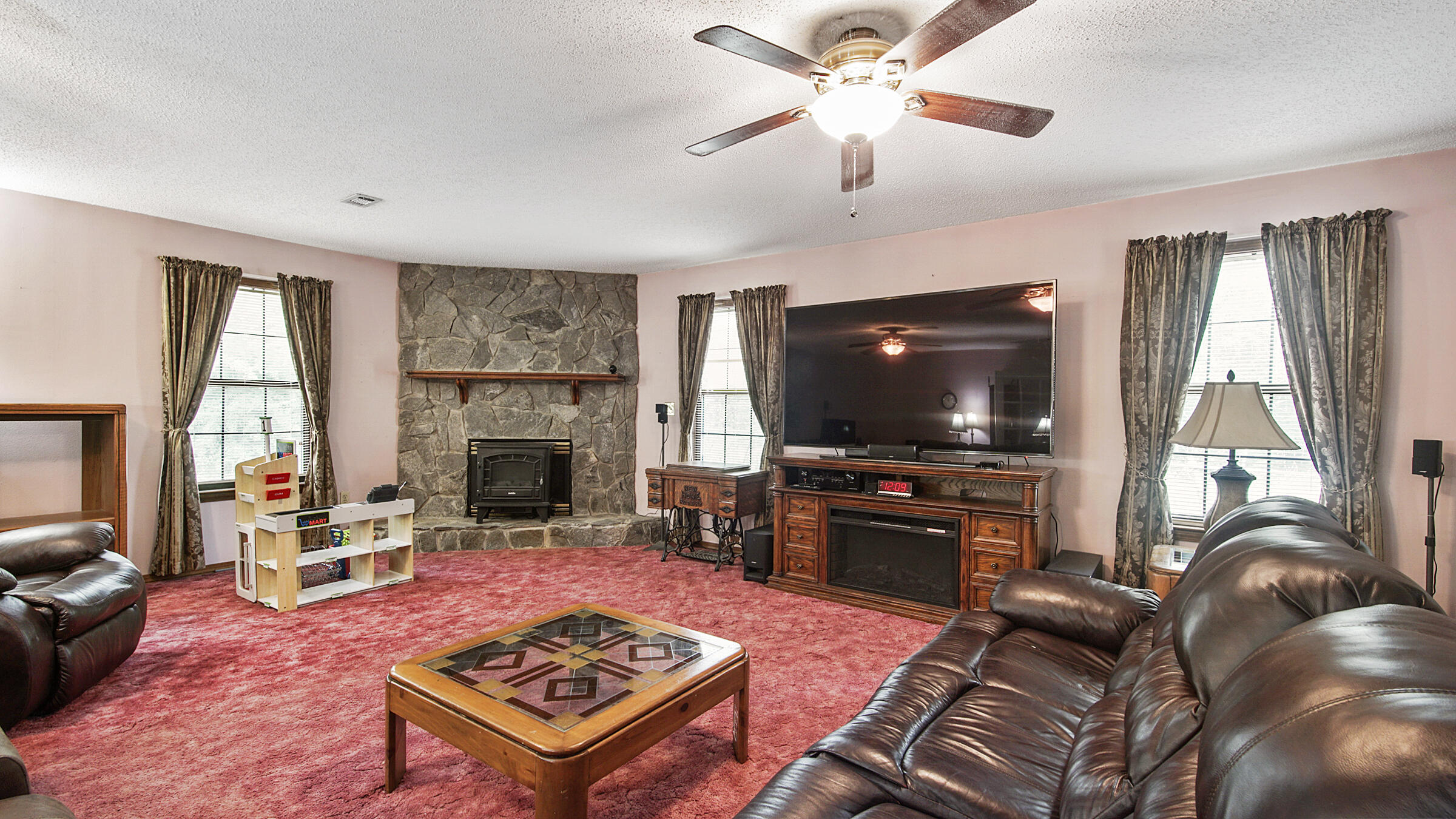 6022 Old Bethel Road Crestview, FL 32536 - Photo 9 of 19 a living room with furniture a flat screen tv and a fireplace