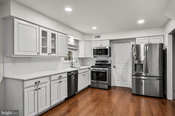 a kitchen with stainless steel appliances granite countertop a refrigerator and a stove top oven