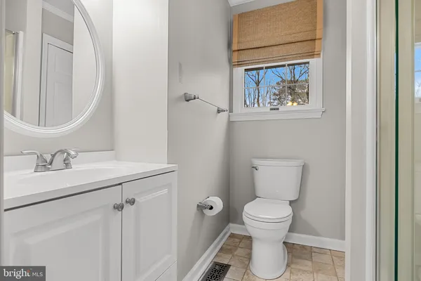 a bathroom with a toilet a sink and a mirror